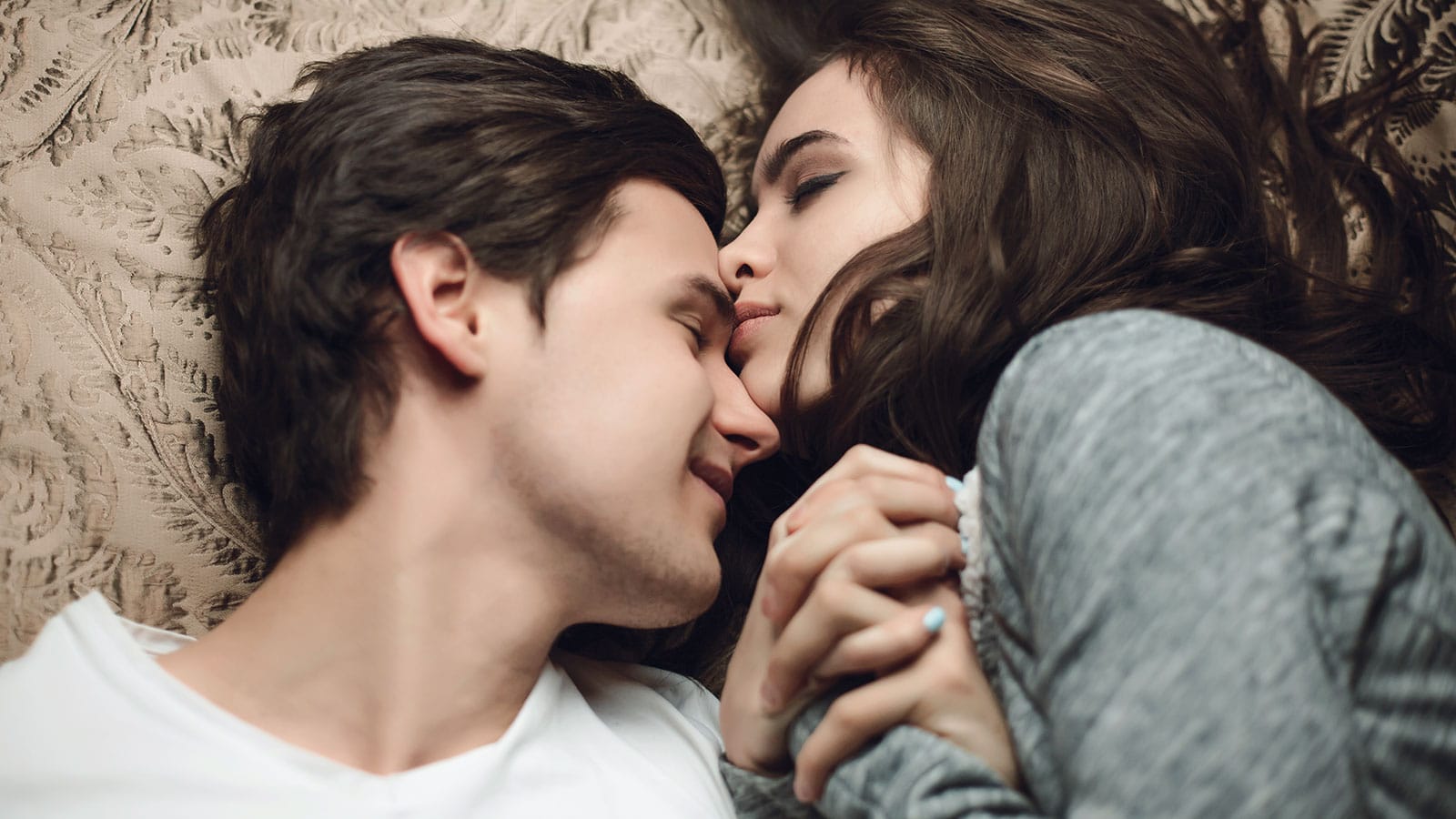 pareja-joven-de-manos-en-cama