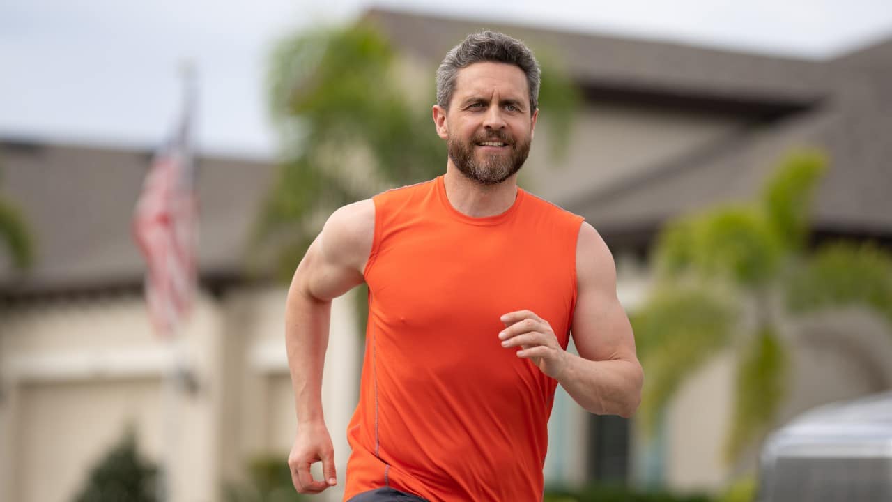 Hombre corriendo al aire libre para reducir el colesterol LDL con ejercicio intenso.