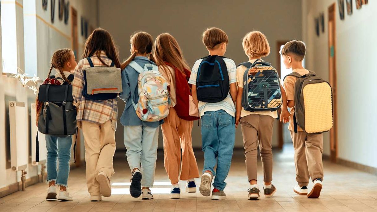 Niños con mochila escolar ergonómica correctamente colocada