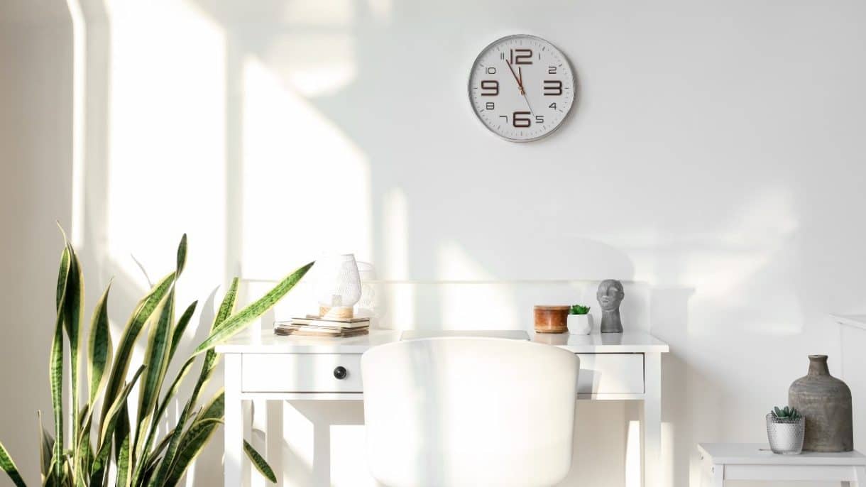 Reloj de pared con luz natural simbolizando los beneficios de no cambiar la hora.