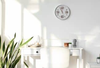 Reloj de pared con luz natural simbolizando los beneficios de no cambiar la hora.