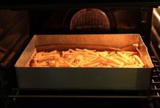 Papas fritas recién horneadas, ejemplo de formación de acrilamida en alimentos.