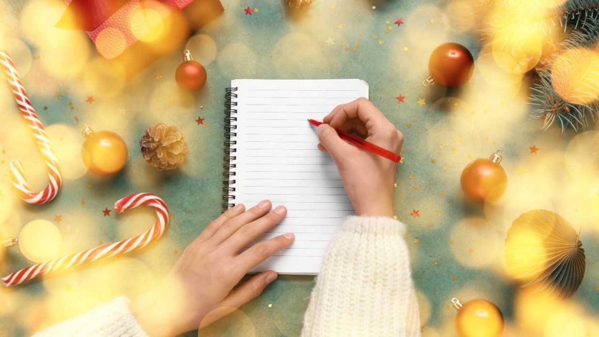 Persona planificando propósitos de Año Nuevo en una libreta