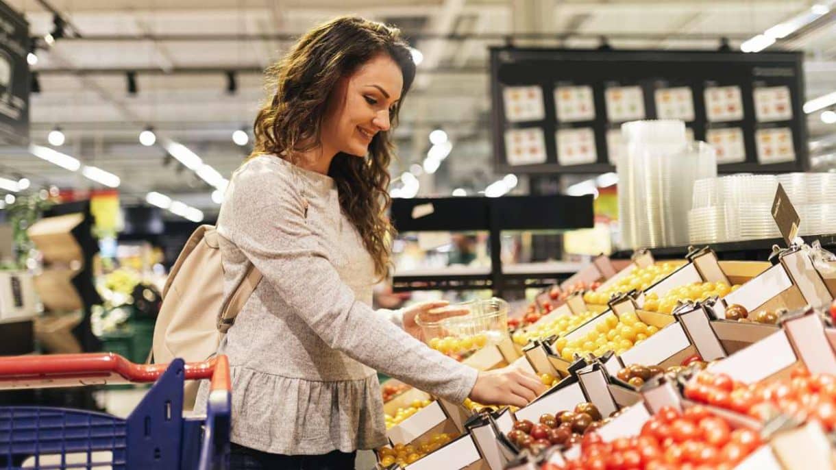 Persona eligiendo frutas y verduras en el supermercado tras usar medicamentos GLP-1