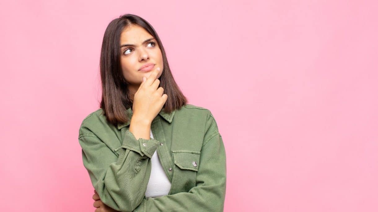 Mujer joven pensativa representando la salud hormonal y la prevención del cáncer.