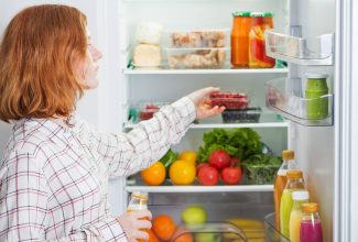 Persona organizando refrigerador para conservar bien los alimentos de forma segura