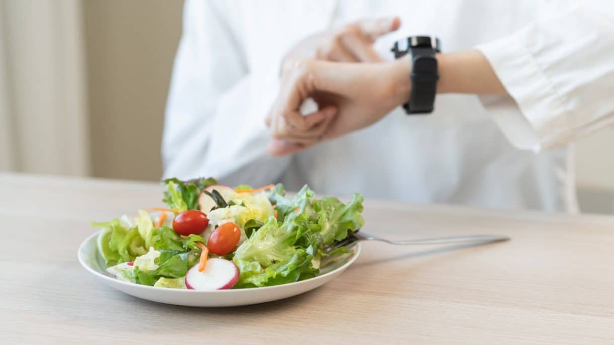 Persona mirando el reloj durante una dieta de ayuno intermitente