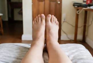 Persona con piernas elevadas por sensación de pesadez e hinchazón