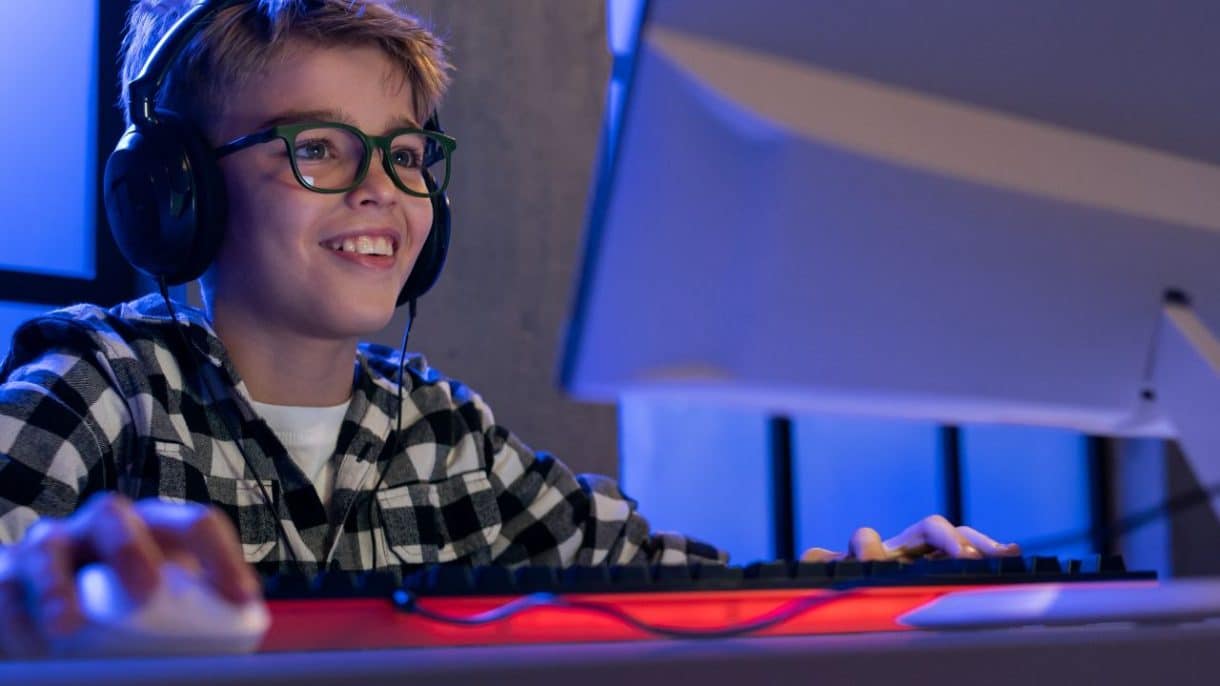 Un adolescente concentrado jugando a un videojuego en su habitación, ilustrando el riesgo de la transición de videojuegos y juegos de azar.