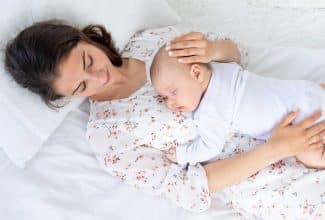 madre en cuidado posparto descansando con su bebé en casa