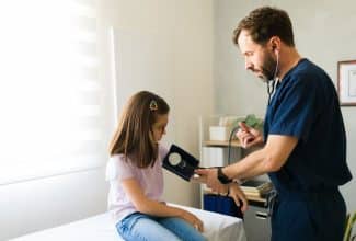 Niño en consulta médica midiendo presión arterial con tensiómetro