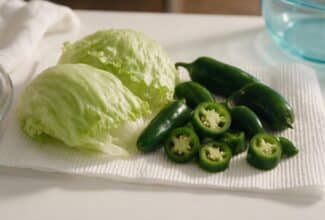 Lechuga y jalapeños frescos preparados sobre una superficie limpia de cocina